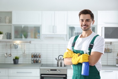 Portrait of janitor with sprayer in kitchen. Cleaning service