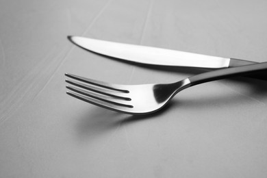 Fork and knife on grey table, closeup