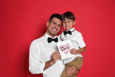 Little boy greeting his dad with Father's Day on red background