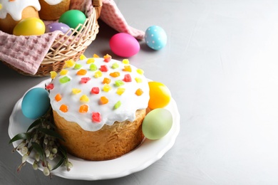 Beautiful Easter cake and painted eggs on light grey table. Space for text