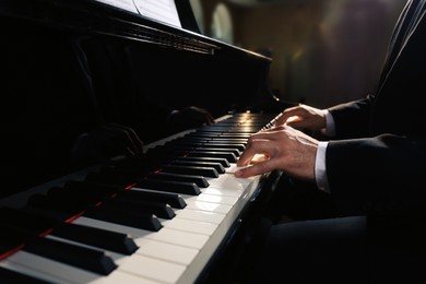 Man playing piano indoors, closeup. Talented musician