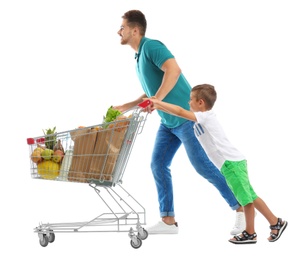 Father and son with full shopping cart on white background
