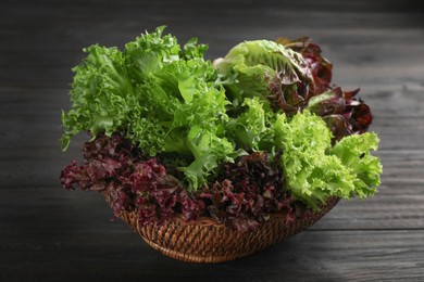 Photo of Different sorts of lettuce on black wooden table