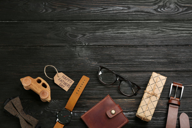 Flat lay composition with male accessories on black wooden background, space for text. Father's Day