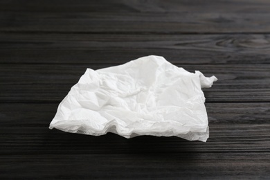 Crumpled paper napkin on wooden table. Personal hygiene