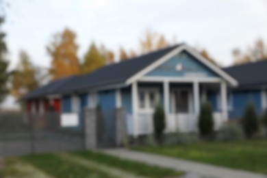 Photo of Blurred view of beautiful light blue house outdoors. Real estate