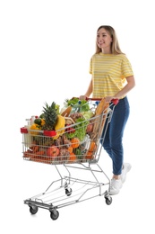 Young woman with shopping cart full of groceries on white background