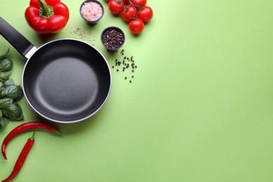 Photo of Flat lay composition with frying pan and fresh products on green background, space for text