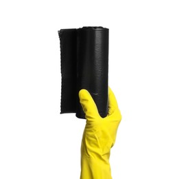 Person in rubber glove holding roll of black garbage bags on white background, closeup. Cleaning supplies