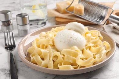 Delicious pasta with burrata cheese on white marble table