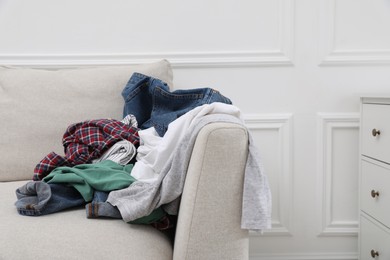 Pile of dirty clothes on sofa in living room
