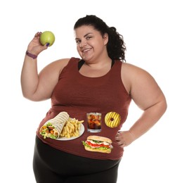Happy overweight woman with apple and images of different unhealthy food on her belly against white background