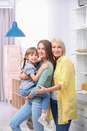 Beautiful mature woman with daughter and grandchild in kitchen