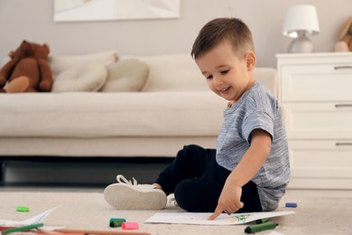Cute child drawing on floor at home