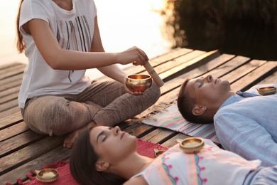 Couple at healing session with singing bowl outdoors