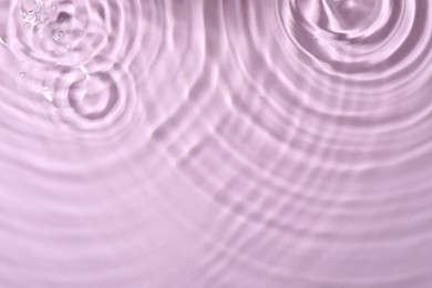 Closeup view of water with rippled surface on violet background