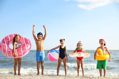 Photo of Cute children enjoying sunny day at beach. Summer camp