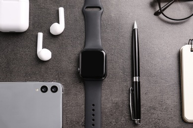 Flat lay composition with stylish smart watch on grey stone table