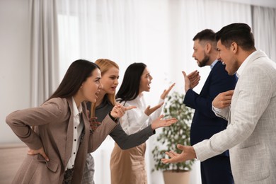 Group of angry coworkers quarreling in office