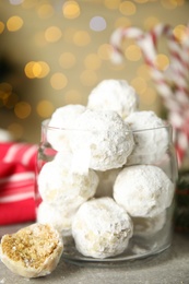 Tasty snowball cookies in glass jar on grey table. Christmas treat