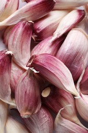 Photo of Unpeeled garlic cloves as background, closeup view
