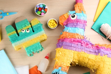 Photo of Flat lay composition with cardboard cactus and donkey on wooden table. Pinata diy