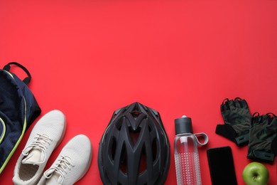 Flat lay composition with different cycling accessories on red background, space for text