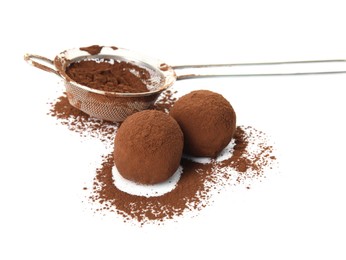 Delicious chocolate truffles and cocoa powder on white background