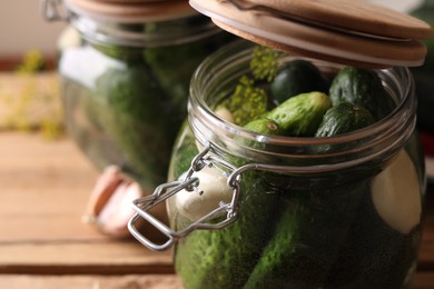 Jar with cucumbers, garlic and dill on wooden table, closeup. Pickling recipe