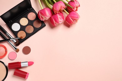 Photo of Flat lay composition with different makeup products and beautiful tulips on beige background, space for text