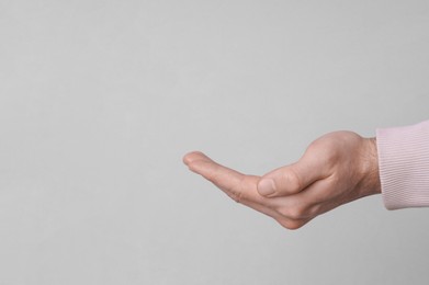 Photo of Female health. Man holding her hand on grey background, closeup with space for text