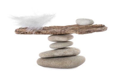 Stack of stones with tree branch and feather on white background. Balance concept