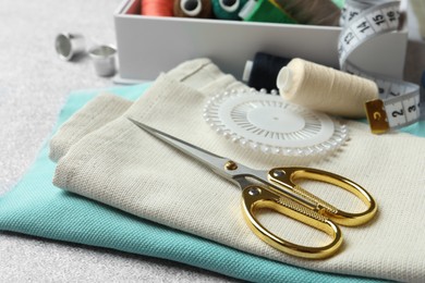 Scissors, spools of threads and sewing tools on table, closeup