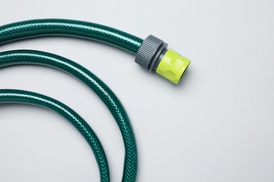 Watering hose on light grey background, top view. Space for text