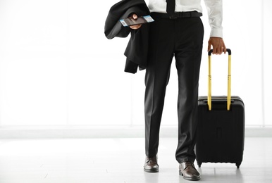 Businessman with black travel suitcase in airport. Space for text