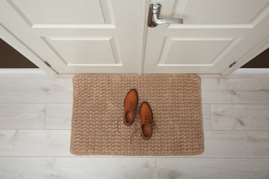 Stylish shoes on door mat in hall, top view