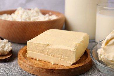 Photo of Piece of tasty homemade butter and dairy products on grey table, closeup