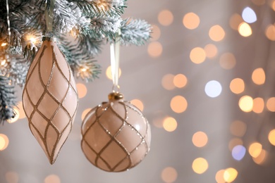 Christmas tree decorated with holiday baubles  against blurred lights, closeup. Space for text