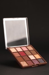 Photo of Colorful eyeshadow palette on black background. Cosmetic product