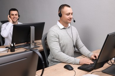Call center operators with headsets working in modern office