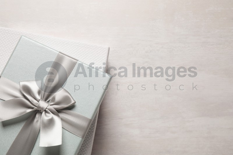 Elegant gift boxes on white table, top view. Space for text