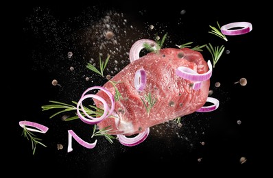 Fresh raw meat and different spices flying on black background