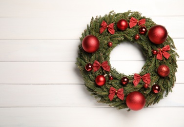 Beautiful Christmas wreath on white wooden background, top view. Space for text