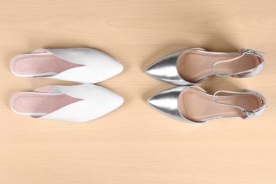 Photo of Different female shoes on wooden background, top view