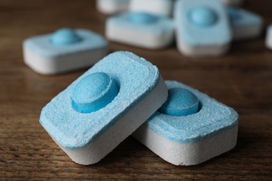 Photo of Water softener tablets on wooden table, closeup