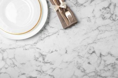 Beautiful table setting on white marble background, flat lay. Space for text