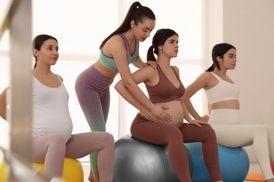Trainer working with group of pregnant women in gym. Preparation for child birth