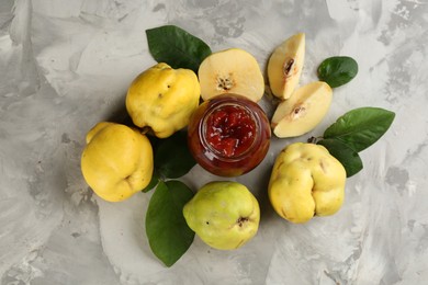 Photo of Delicious quince jam and fruits on light grey table, flat lay