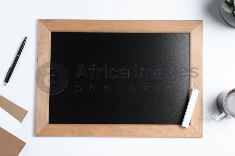 Flat lay composition with small chalkboard on white background, space for text