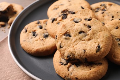 Photo of Delicious chocolate chip cookies on grey plate, closeup